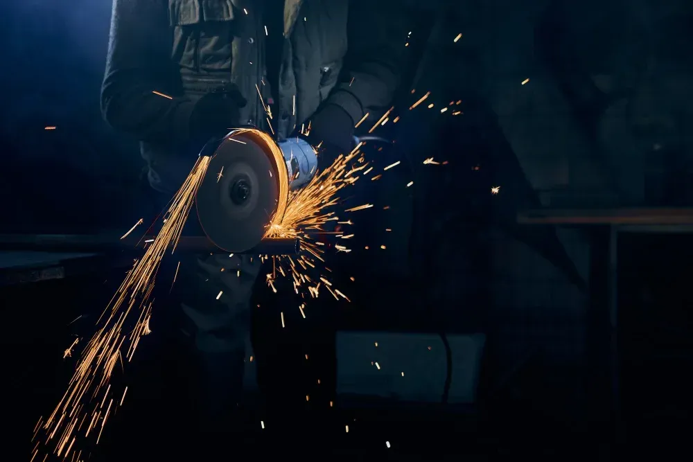 Welder cutting steel inside an operating Fox Valley manufacturing plant